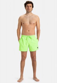 Neona zaļi peldbikses no viegla materiāla, ar elastīgu jostasvietu, kurai ir aukliņa, un sānu kabatām.