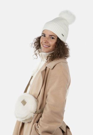 Berretto lavorato a maglia bianco con pompon, cappotto in fleece beige, maglione bianco con colletto alto e borsa a tracolla rotonda in pelliccia bianca con etichetta.