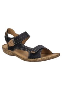 Musta nahkasandaali avoimella varvastyylillä, säädettävällä hihnalla, vaaleanruskeilla yksityiskohdilla ja teksturoidulla kumipohjalla paremman pidon takaamiseksi. Valkoiset tikkaukset koko kengän ympäri.