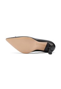 Scarpa nera in pelle con tacco alto, punta affusolata e tacco sottile, caratterizzata da una texture liscia e una suola color nude con dettagli minimi.