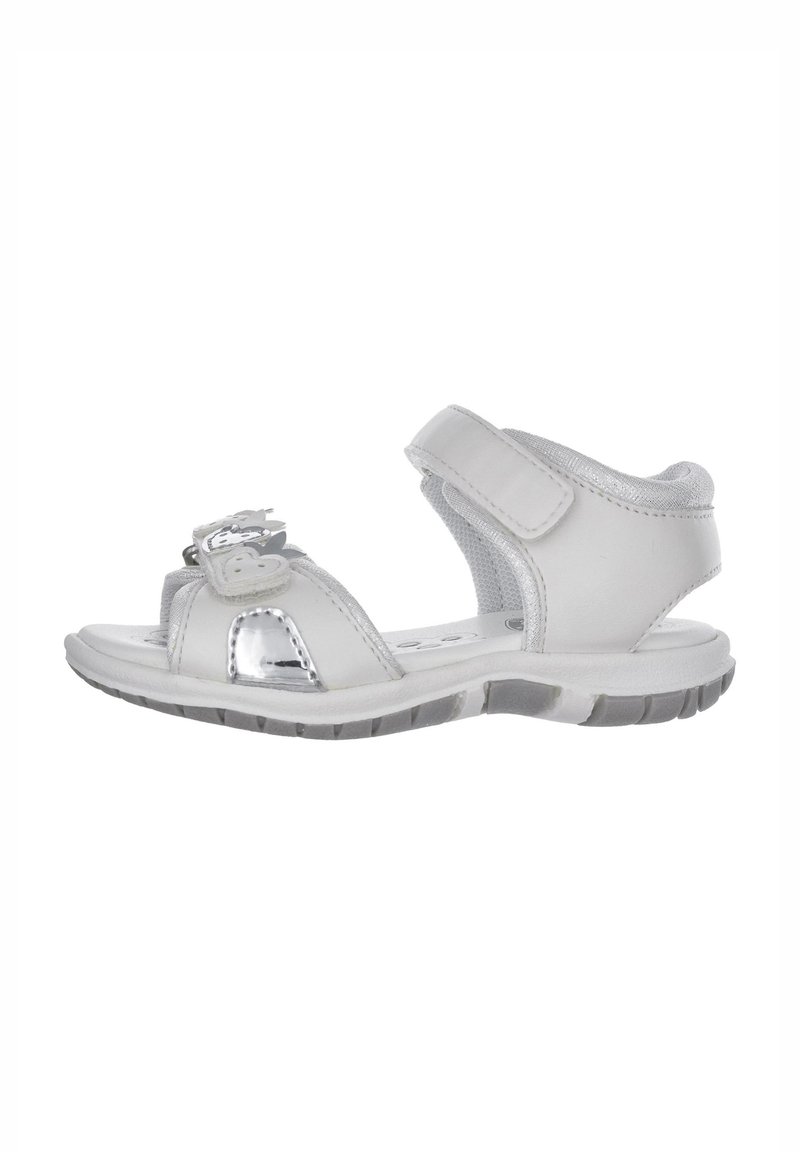 Sandal bianco con una cinghia alla caviglia imbottita, dettagli metallici e chiusura con velcro, dotata di una suola testurizzata per la presa.