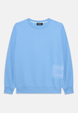 Lyseblå hettegenser med lange ermer, rund hals, ribbestrikkede mansjetter og nederkanten. Har en subtil logo-trykk på forsiden.