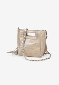 Bolso de mano beige con estampado de cocodrilo, con un asa cortada en forma rectangular, correa de cadena plateada y flecos en los lados.