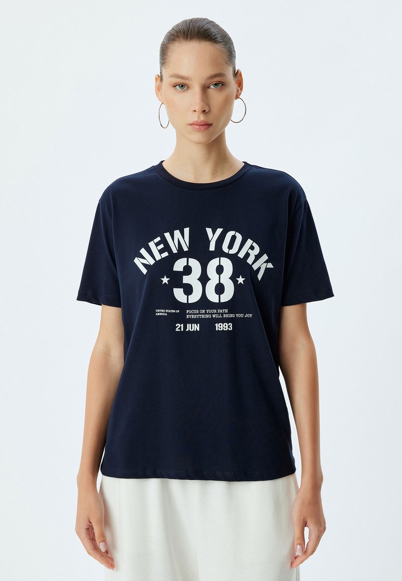 Camiseta de algodón azul marino con un estampado gráfico blanco que dice "NEW YORK 38" y texto adicional. Manga corta, escote redondo, corte holgado.