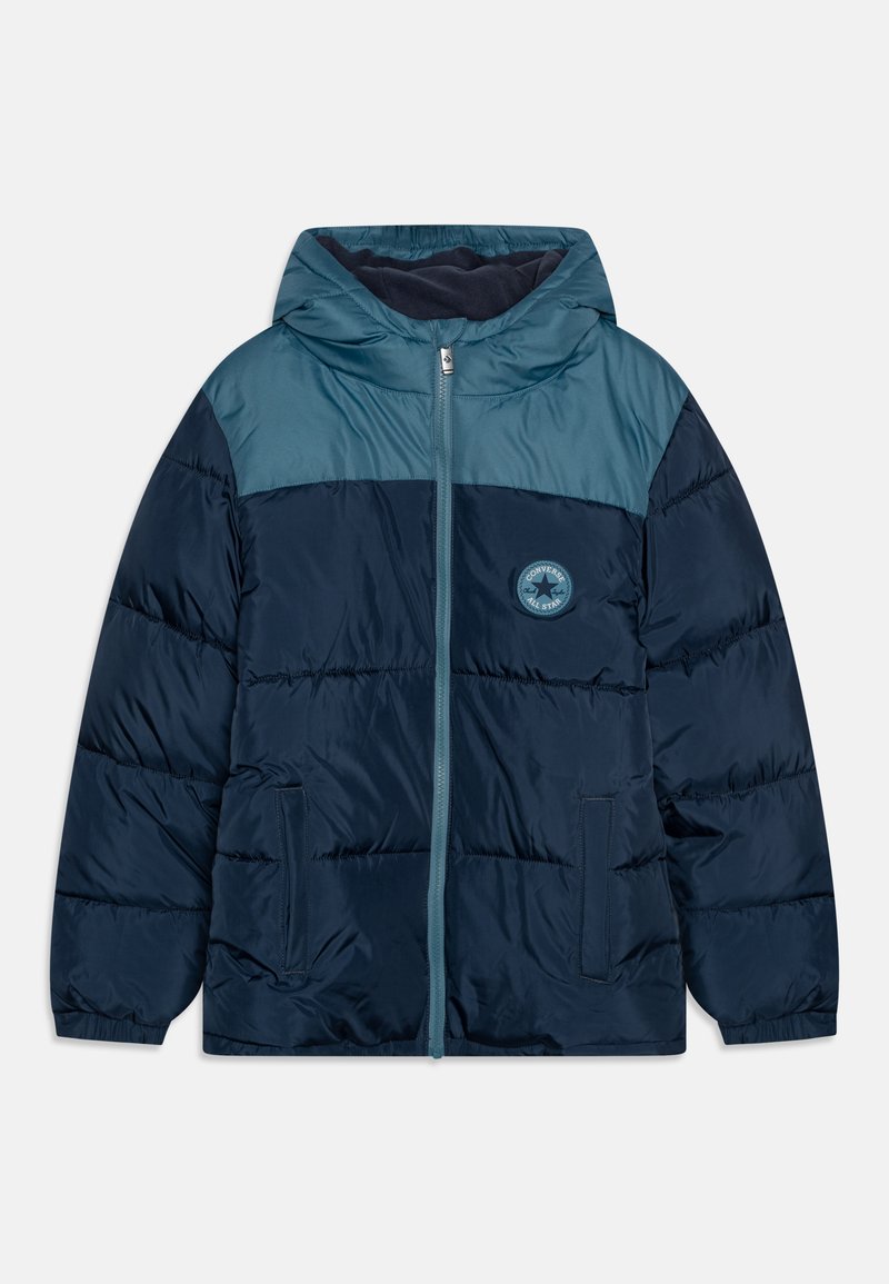 Marineblaue Steppjacke mit einer türkisfarbenen Kapuze und oberen Teil, Reißverschluss vorne, zwei Seitentaschen und einem runden Logo-Patch auf der linken Brust.