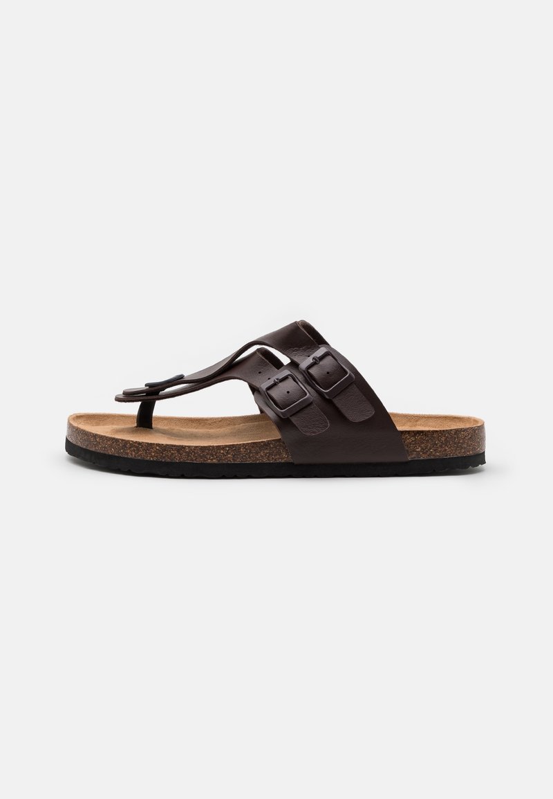 Brun læder-sandal med rem mellem tæerne, to justerbare remme med spænder og korksula på sort gummisål, vist i sideprofil.