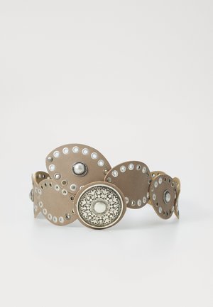 Brun læderarmbånd med cirkulære udskæringer, sølvdetaljer og dekorative metalplader med indviklede mønstre og nitter.