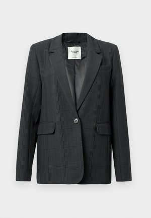 Blazer carouri gri închis cu rever clasic, închidere cu un singur nasture și buzunare frontale.Țesătură netedă cu o textură subtilă. Interior căptușit.