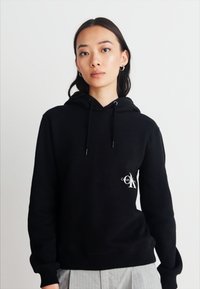 Calvin Klein Jeans OFF PLACED MONOLOGO HOODIE  - Felpa - black