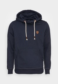 Námořnická modrá mikina s kapucí vyrobená z bavlněné směsi, s přední kapsou, nastavovací šňůrkou na kapuci a koženou nášivkou v béžové barvě na hrudi.