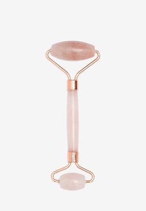 Rouleau facial en quartz rose avec un cadre fin en or rose. Présente un sommet ovale et une extrémité plus petite pour une application ciblée. Texture lisse et polie.