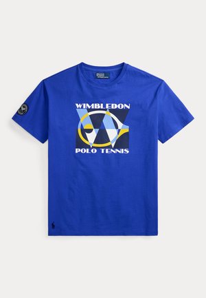 Μπλε κοντομάνικη μπλούζα με το κείμενο Wimbledon Polo Tennis και αφηρημένο γεωμετρικό σχέδιο ρακέτας τένις στο μπροστινό μέρος, και στρογγυλό μαύρο σημείο στο μανίκι.
