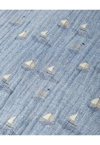 Tela azul con un sutil patrón de pequeños veleros sobre olas, con velas beige y contornos en un azul más oscuro, y un acabado texturizado.