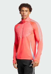 Felroze sportieve langefsleevetop met een halve rits, gevoerd borstgedeelte en grijze accentstrepen op de schouders en zijkanten.