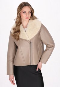 Giacca in pelle beige con un ampio colletto in shearling crema, chiusura con zip e maniche lunghe, caratterizzata da una silhouette aderente e una texture liscia.