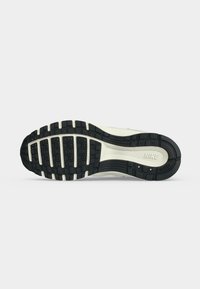 Σόλα ενός παπουτσιού τρεξίματος Nike με ασπρόμαυρο σχέδιο πέλματος και ορατό λογότυπο Nike στην περιοχή της φτέρνας.