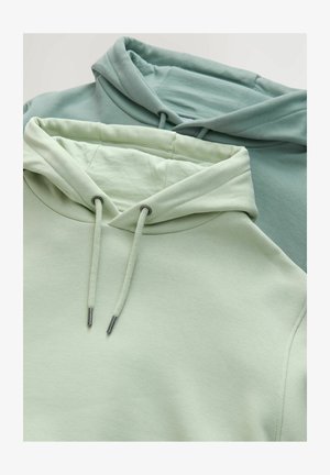 To svedtrøjer i bløde grønne nuancer, en lys og en mørkere. Funktioner inkluderer snore med metalspidser og en glat tekstur.