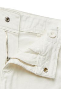 Witte katoenen broek met metalen ritssluiting, knoopsluiting en versterkte stiksels. Interne zak met subtiele stofstructuur details.