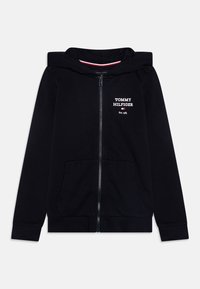 Sudadera con capucha negra con cremallera, hecha de algodón, con dos bolsillos delanteros, puños acanalados, capucha forrada y "TOMMY HILFIGER" bordado en blanco.