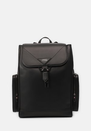 Czarny prostokątny plecak z klapką i zapięciem na klamrę, boczne kieszenie na zamek oraz małe logo na przedniej klapce.