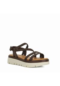 Sandale en cuir tressée marron avec une semelle plate-forme blanche épaisse et un revêtement de pied marron texturé. Boucle ajustable sur la sangle de la cheville.