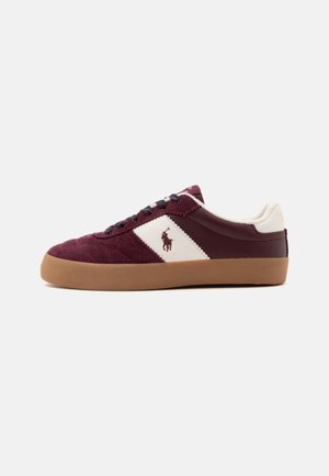 Baskets basses en daim et cuir bordeaux avec panneau latéral blanc, semelle en caoutchouc marron, lacets noirs et logo d'un joueur de polo à cheval.