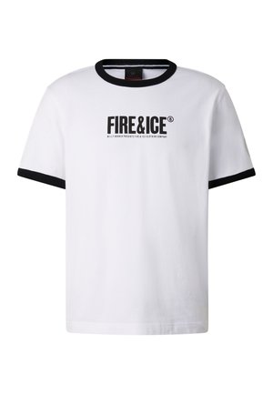 Junger Mann mit großen schwarzen futuristischen Sonnenbrillen, weißem "FIRE&ICE" T-Shirt, schwarzen Hosen, gebundener Jacke und schwarzen Sneakers, stehend.