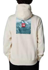Sudadera color crema con un gráfico de montaña azul y un logotipo rojo en la parte posterior. Material: mezcla de algodón suave; diseño: ajuste relajado.