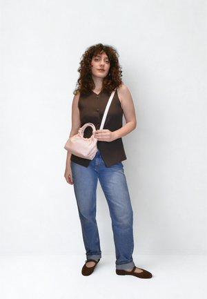 Καφέ αμάνικη μπλούζα με κουμπιά, μπλε τζιν, καφέ φλατ παπούτσια και μια μικρή ροζ δερμάτινη τσάντα χειρός με πτυχωτό σχεδιασμό και χερούλι.