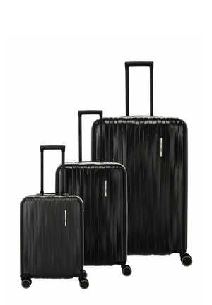 Tres maletas negras de carcasa dura en tamaños pequeño, mediano y grande, cada una con asas extensibles y cuatro ruedas giratorias.