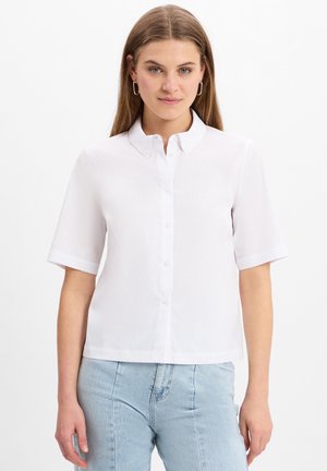 Kortarmig wit shirt met een button-down kraag, voorzien van een gladde textuur en een rechte snit, gecombineerd met lichtblauwe jeans.