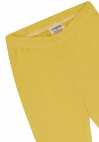Geel katoenen legging met een zachte textuur, voorzien van een elastische tailleband en een label aan de binnenkant. Geen patronen of bevestigingsmiddelen zichtbaar.