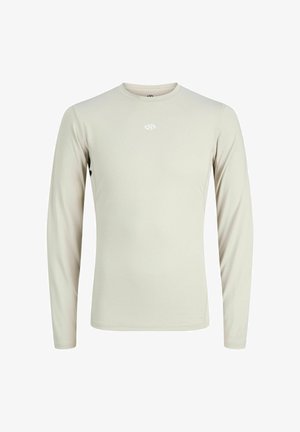 T-shirt de sport beige clair à manches longues avec un petit logo blanc centré sous l'encolure ronde, vu de face.