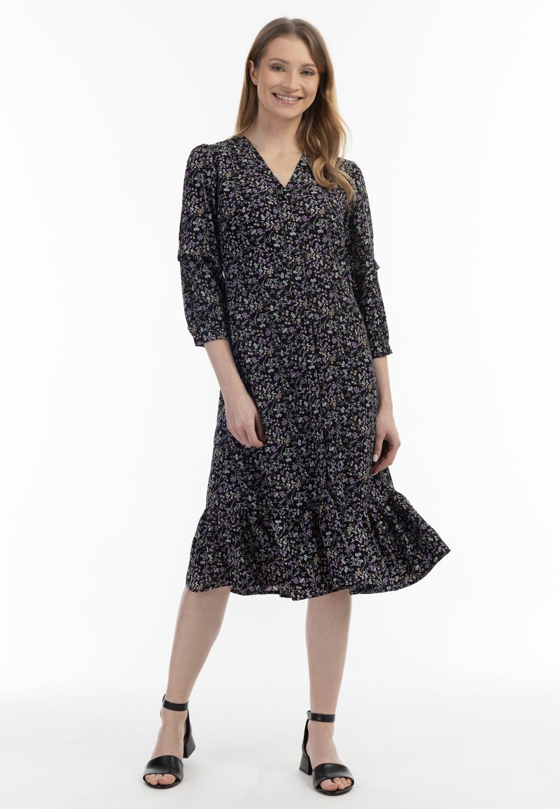 Rochie midi neagră cu imprimeu floral, cu decolteu în V, mâneci trei sferturi și tiv franjurat, având motive florale în nuanțe de violet și alb.