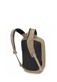 Sac à dos tan et noir présentant un design moderne et épuré. Bretelles rembourrées, texture lisse et esthétique minimaliste avec quincaillerie en argent.