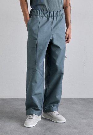 Light blue cargo pants with an elastic waistband, side pockets, and a tapered design, made of a smooth, durable fabric.