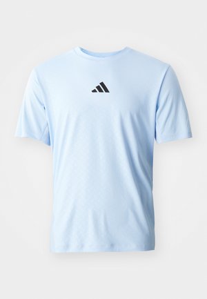 Lichtblauw sportshirt van gladde stof. Heeft korte mouwen, een ronde hals en een zwart Adidas-logo op de borst.