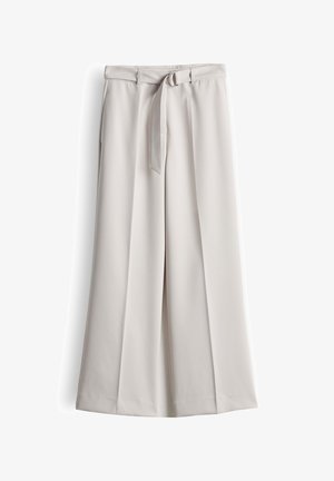 Light beige wide-leg trousers with front pleats and a matching fabric belt with a silver D-ring buckle.