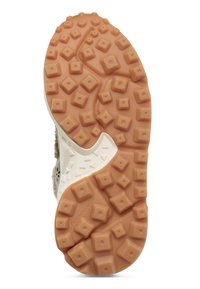 Podešev boty se zvýšenými čtvercovými a obdélníkovými vzorky z lehce hnědé gumy pro lepší trakci, zobrazující část bílé mezipodešve a horní hranu.