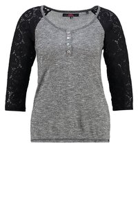 Top grigio a maniche lunghe con corpo testurizzato e maniche in pizzo nero. Presenta un collo a barca e tre bottoni decorativi sul davanti.