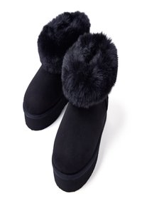 Stivaletti neri in suede con un morbido polsino in pelliccia sintetica, punta rotonda e suola piatta, caratterizzati da una texture liscia e senza hardware visibile.