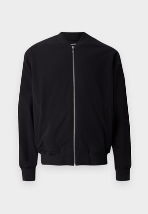 Mustus bomber-jakk, millel on sile esi lukk, soonikkoesed ja -äär, küljetaskud ning sile kanga tekstuur. Lihtne ja klassikaline disain.