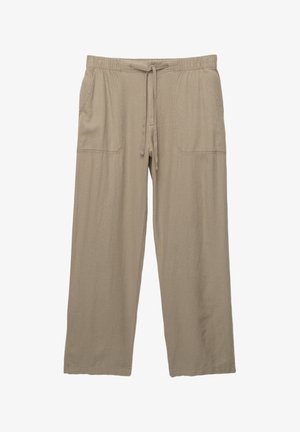 Beige, wijde broek van zacht materiaal, met een elastische tailleband en trekkoord, en twee zijzakken.