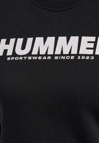 Czarna bluza z wyrazistym białym napisem "HUMMER SPORTSWEAR SINCE 1923". Gładka tekstura materiału i ściśle przylegający dekolt.