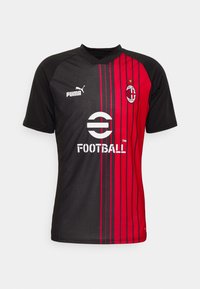 Camisa de fútbol negra y roja con rayas verticales, con cuello en v, logo de Puma a la izquierda y emblema del AC Milan en el pecho.