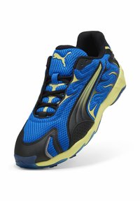 Chaussure de sport en mesh bleu avec des accents noirs et jaunes, dessus texturé, semelle rembourrée et logo Puma bien visible au niveau du talon.