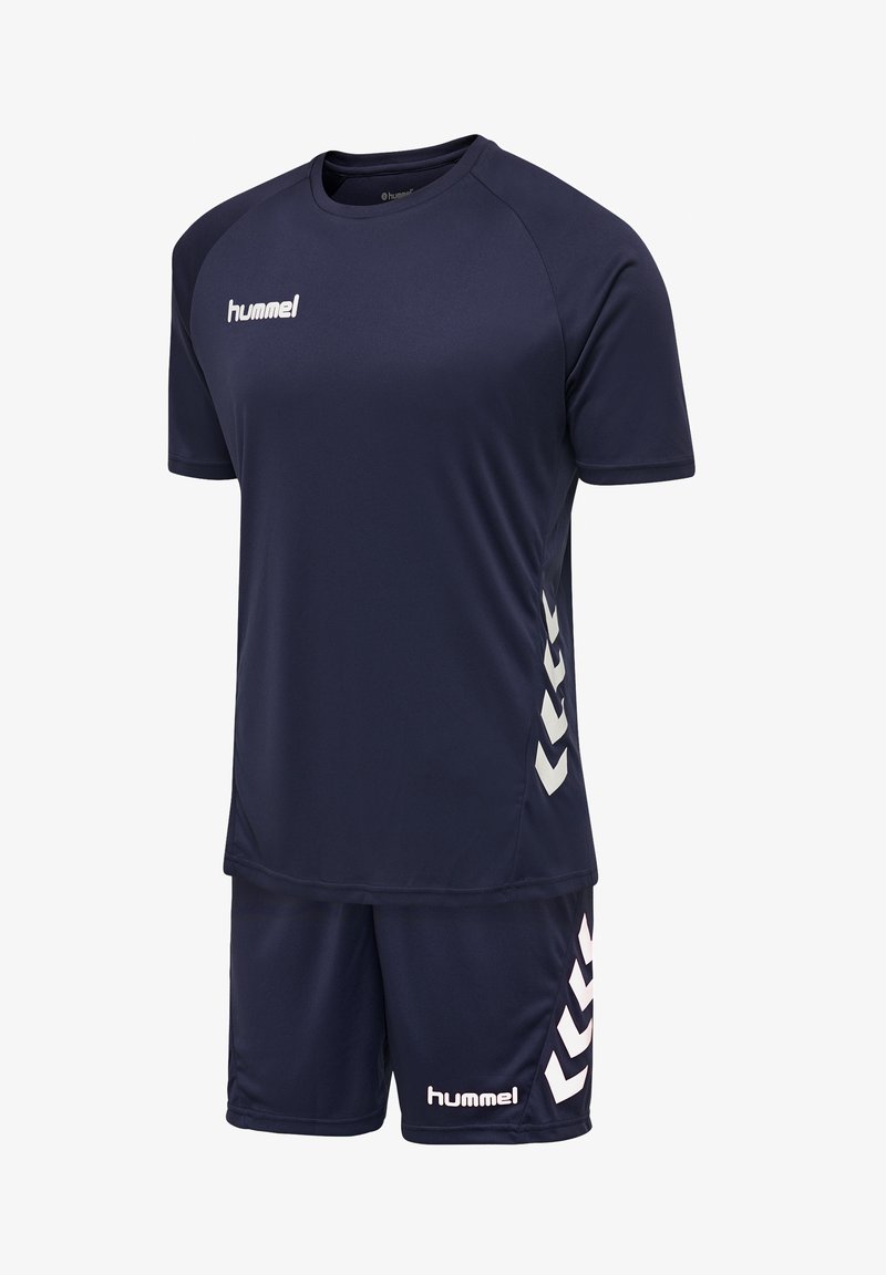 Navy sportsudstyr inkluderer en kortærmet top og shorts. Har hvidt logo og chevron-detaljer på siden. Fremstillet af letvægts, åndbart materiale.