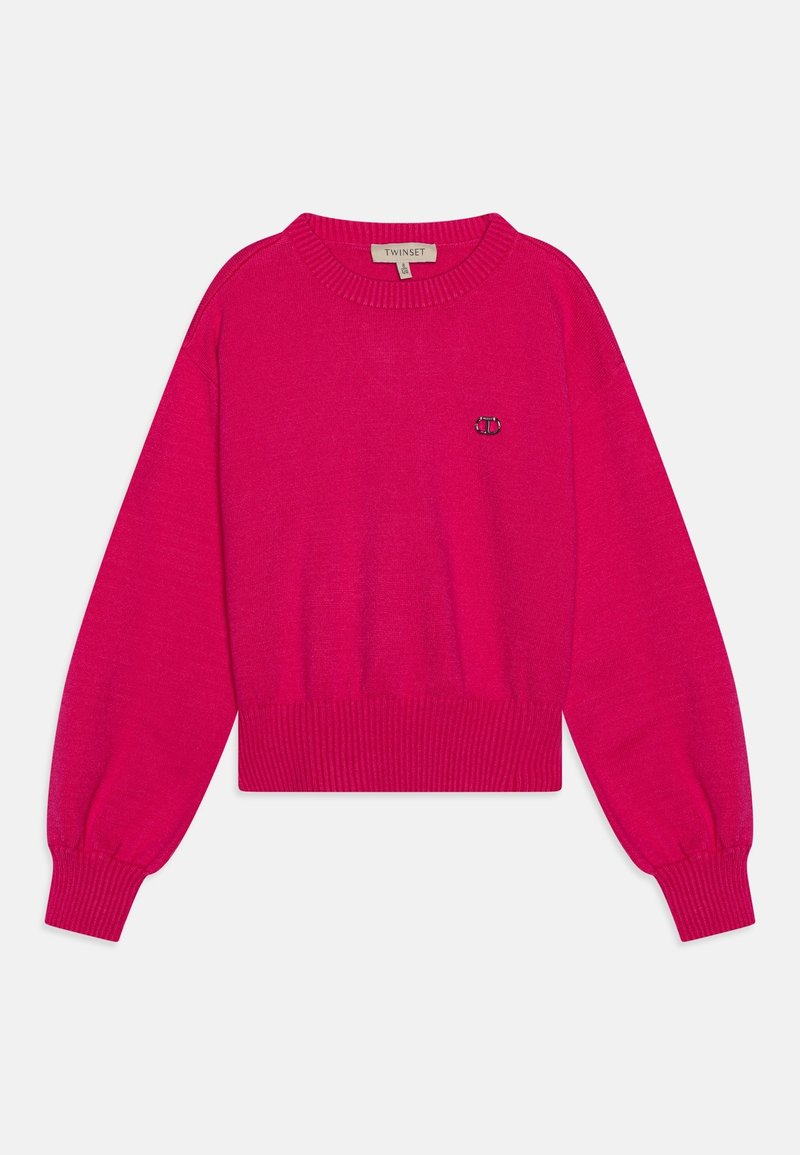 Pull court fuchsia en tissu tricoté doux, avec poignets et ourlet côtelés, arborant un petit logo sur la poitrine.