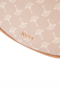 Borsa beige con superficie testurizzata, decorata con un motivo floreale bianco e il logo "JOOP!" dorato sulla parte anteriore.