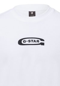 Hvid bomulds-t-shirt med et fremtrædende sort G-Star-logo i oval form, rund halsudskæring og blød tekstur.